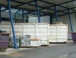mehrere Container auf einer überdachten, asphaltierten Fläche